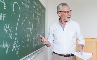 aged-math-teacher-explaining-formula-classroom